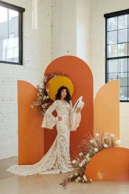 07-a-chic-70s-wedding-backdrop-with-orange-rust-and-yellow-parts-a-sun-and-pastel-and-neutral-florals-and-dried-grasses